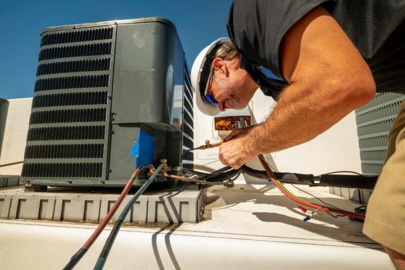 Technician conducting air conditioning repair service
