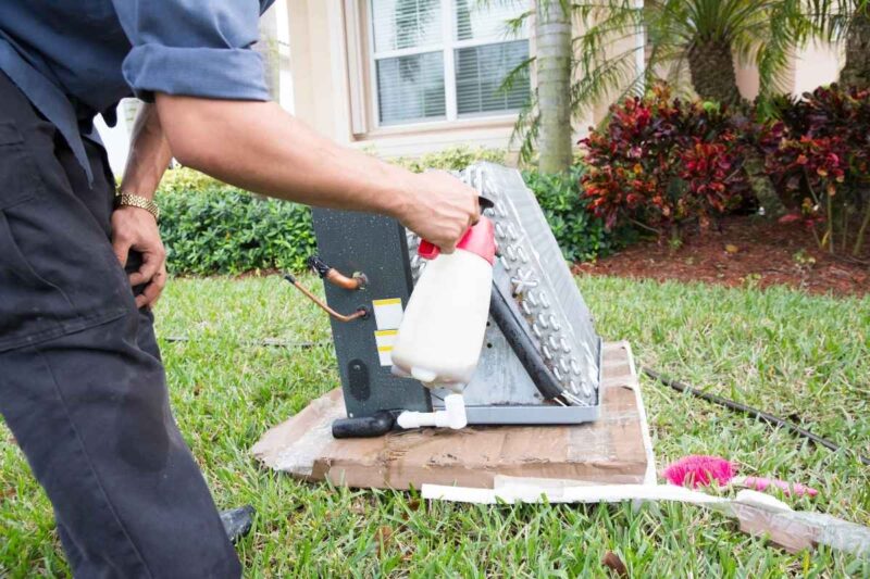 Technician cleaning ac evaporator coil
