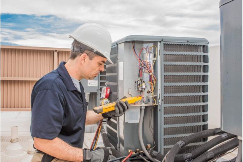 Technician conducting air conditioning maintenance